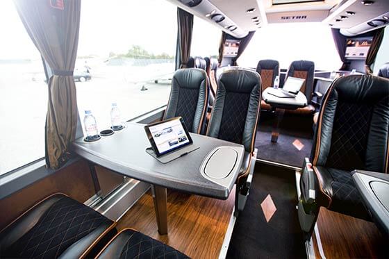 Innenraum eines VIP-Busses mit Arbeitstischen.